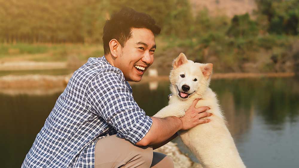 Man and husky at lake.