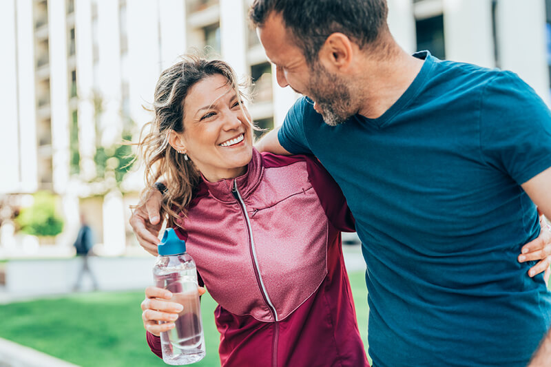 Man and woman with their arms around one another smiling