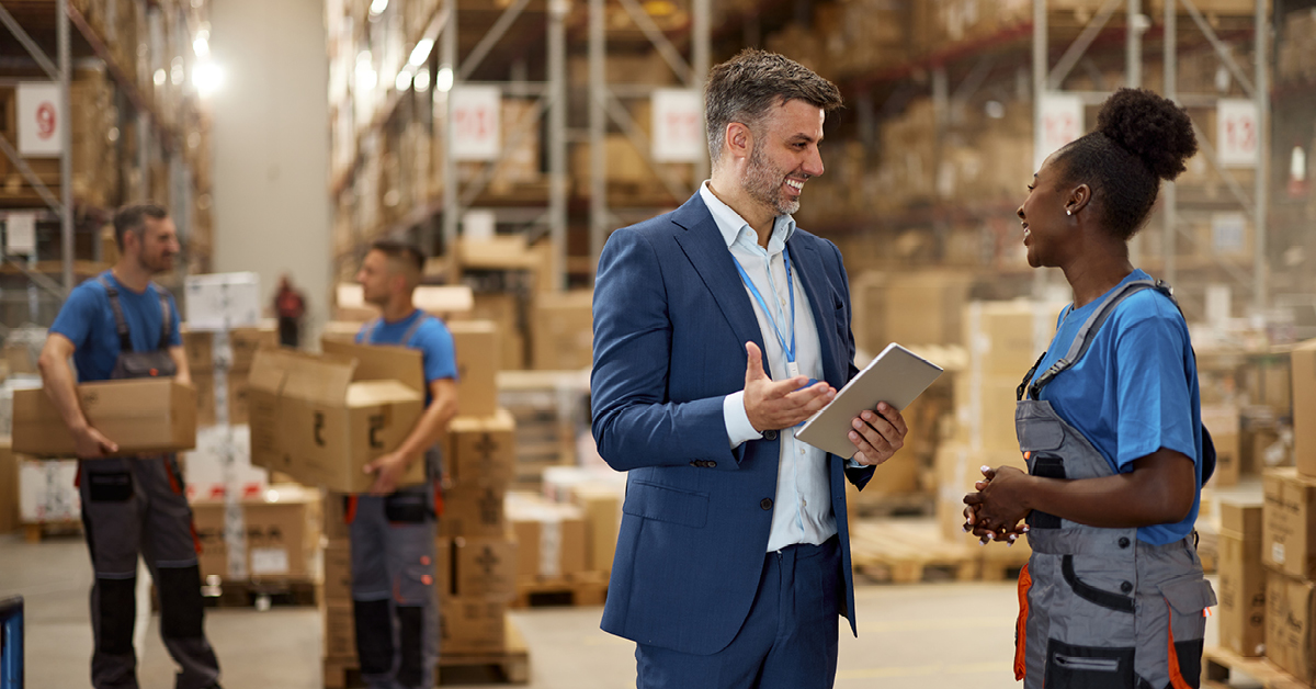 man speaking to woman in warehouse
