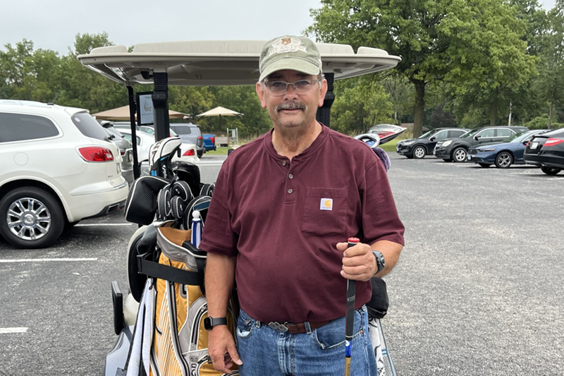 Brian Lake standing in front of a golf cart