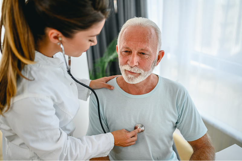 A doctor listening to a man's lungs